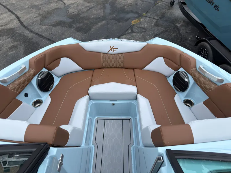 Slide: The Image of The image shows the bow area of a 2027 MasterCraft XT20 with brown and white upholstery. - 50