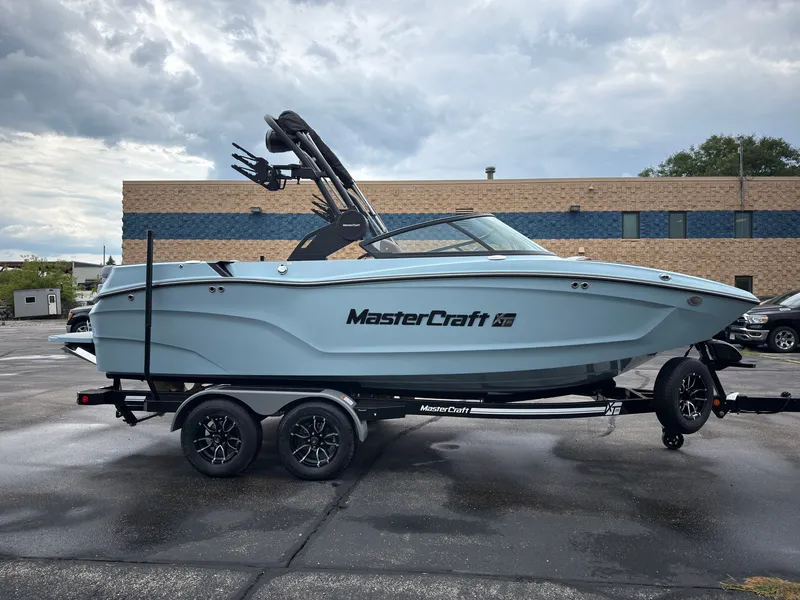 Slide: The Image of A 2027 MasterCraft XT20 boat on a trailer in front of a building. - 4