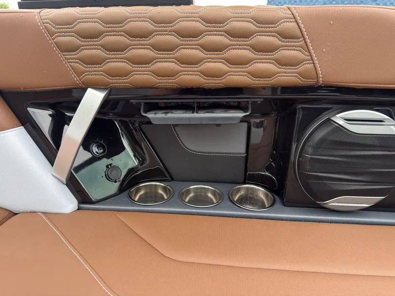 Slide: The Image of Close-up of a boat interior with brown upholstery, speaker, and cup holders. - 27