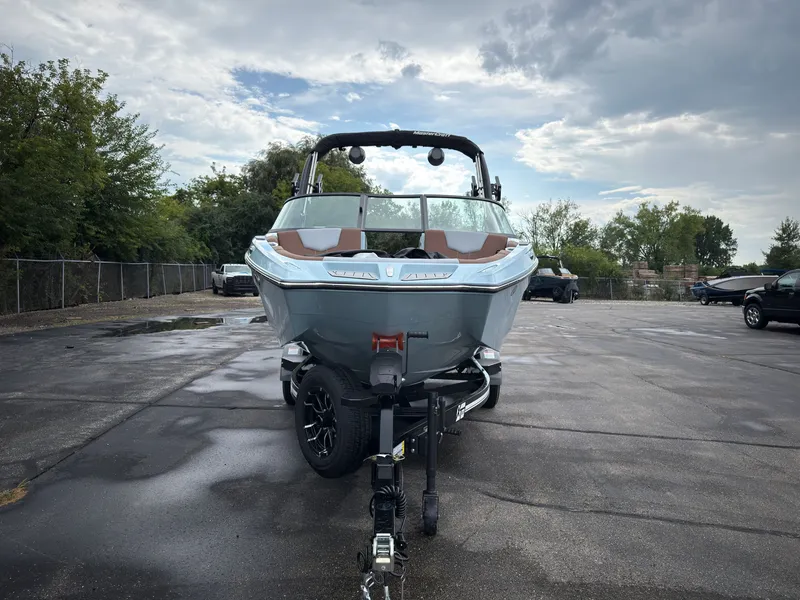 Slide: The Image of A 2027 MasterCraft XT20 boat on a trailer in a parking lot. - 2