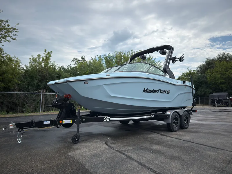 Slide: The Image of A 2027 MasterCraft XT20 boat on a trailer in a parking lot. - 1