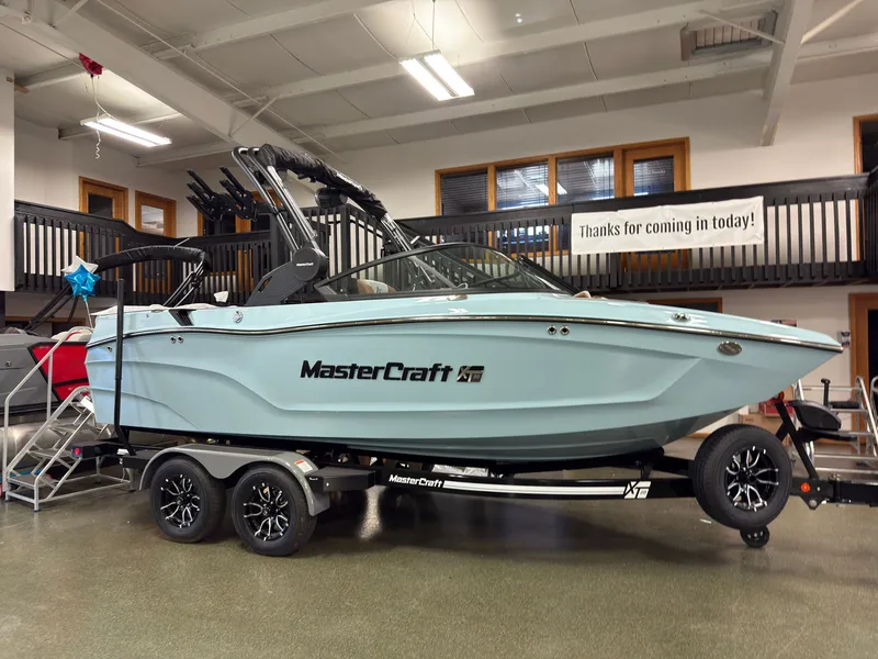 The Image of A 2027 MasterCraft XT20 boat on a trailer in a showroom setting. - 0
