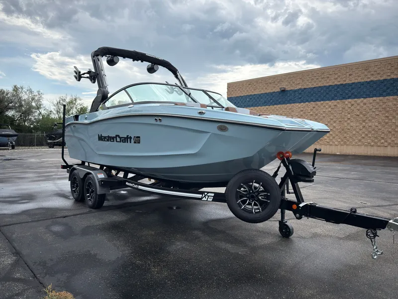 Slide: The Image of A 2027 MasterCraft XT20 boat on a trailer in a parking lot. - 3