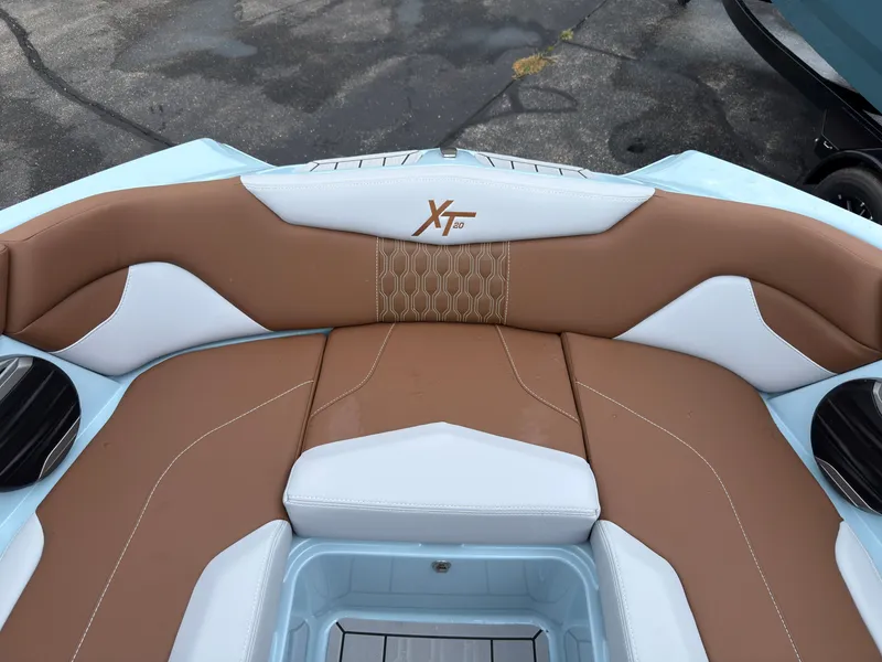 Slide: The Image of The image shows the brown and white upholstery in the bow area of a MasterCraft XT20 boat. - 52