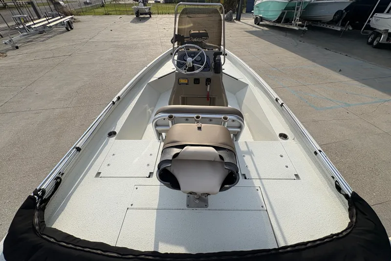 Slide: The Image of 2019 Excel 203 Bay Pro boat interior with steering console and seating, parked outdoors. - 10