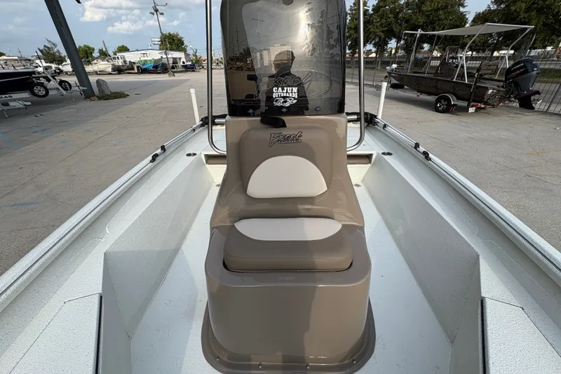 Slide: The Image of 2019 Excel 203 Bay Pro boat interior with seating and console, parked outdoors. - 14