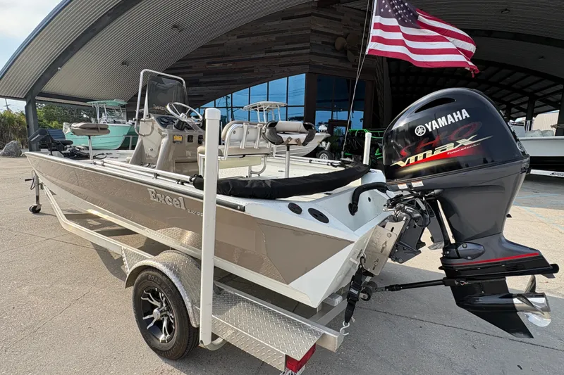 Slide: The Image of 2019 Excel 203 Bay Pro boat with Yamaha engine, parked under a canopy with American flag. - 8
