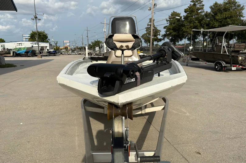 Slide: The Image of 2019 Excel 203 Bay Pro boat on trailer, featuring a trolling motor, parked outdoors. - 2