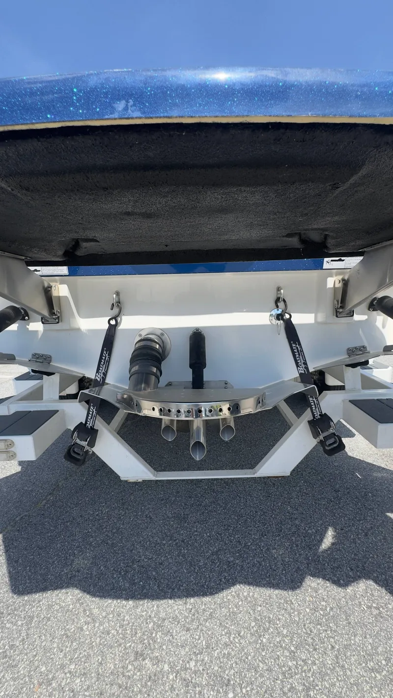 Slide: The Image of The image shows the rear of a blue 2022 Supreme S220 boat with exhaust pipes. - 17