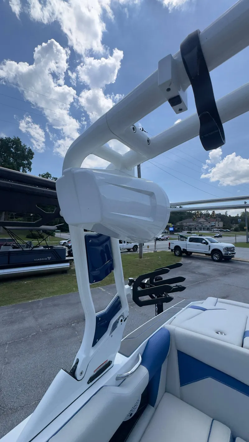Slide: The Image of A modern boat with blue and white upholstery and a sturdy wakeboard tower under a cloudy sky. - 12