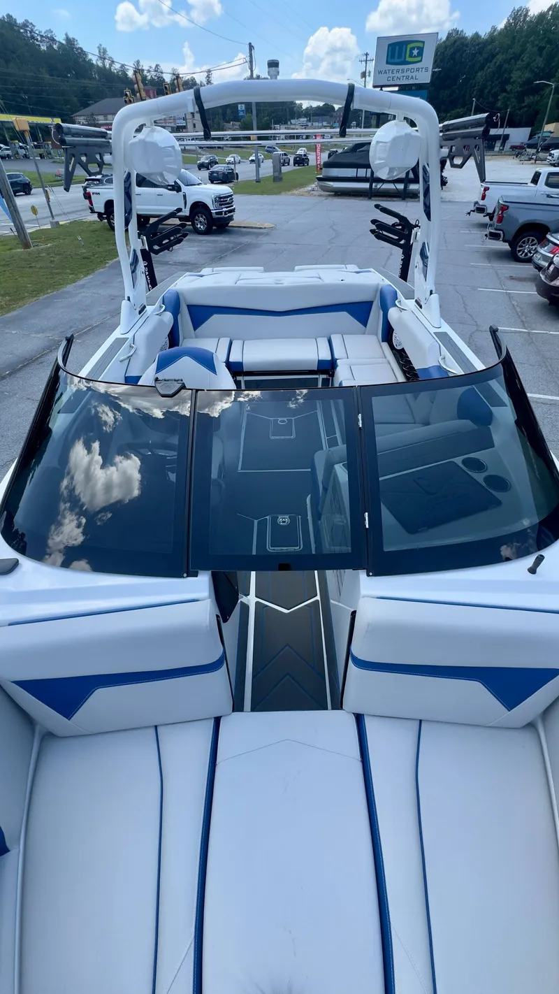 Slide: The Image of The image shows a modern motorboat with white and blue upholstery, parked in a lot. - 5