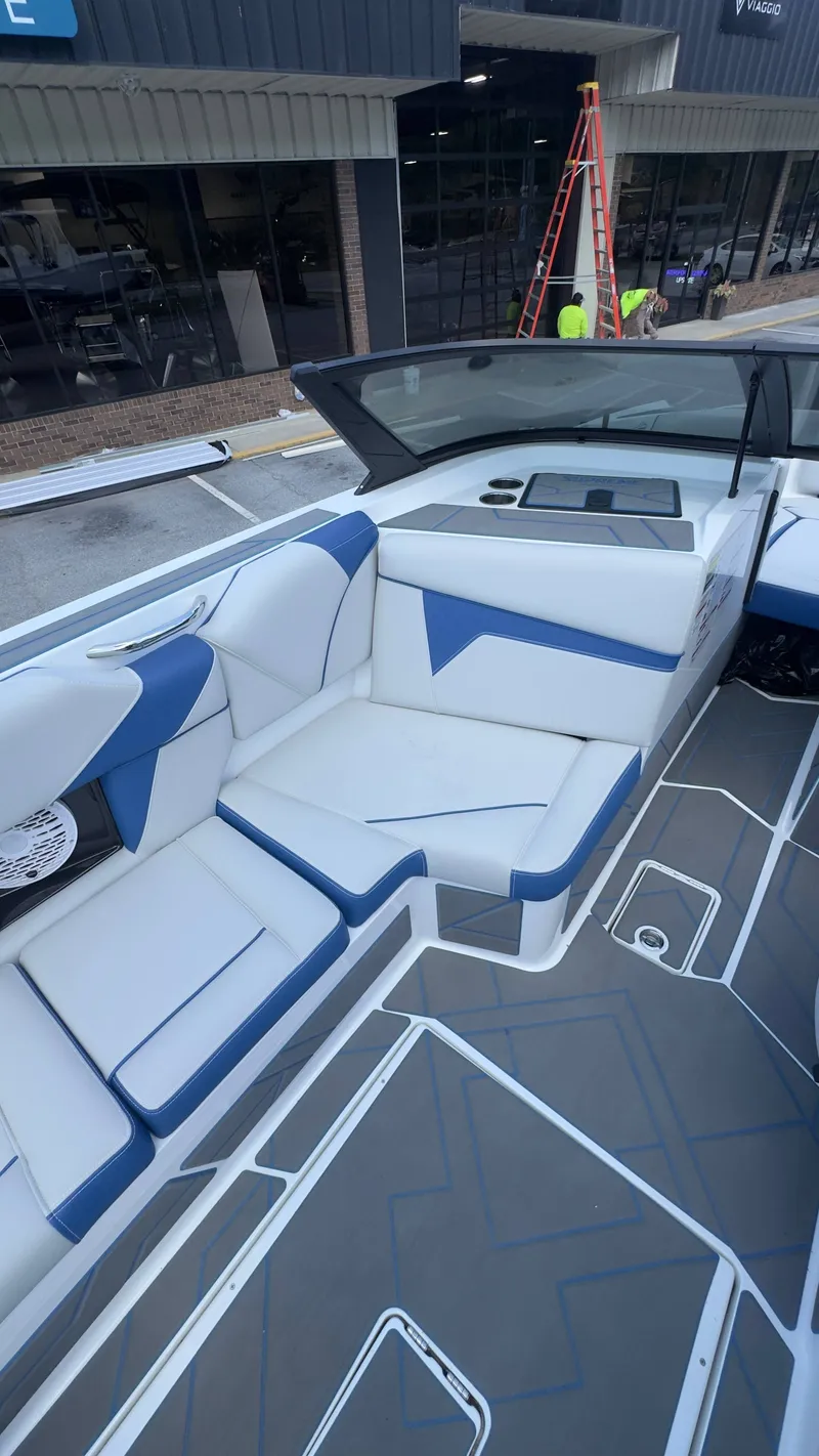 Slide: The Image of The image shows the interior of a 2022 Supreme S220 boat with blue and white seating. - 6