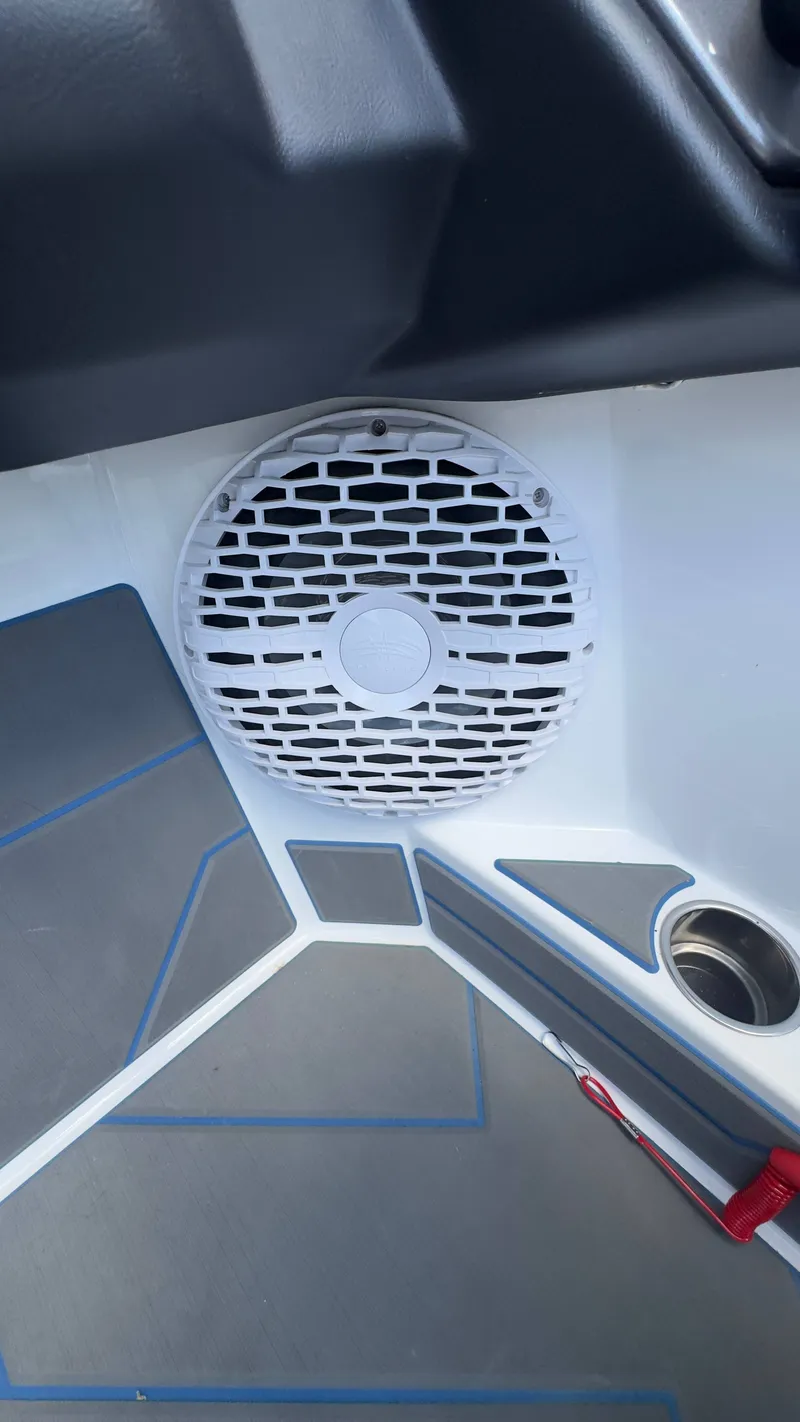 Slide: The Image of A speaker is integrated into the boat's white interior paneling, with a cup holder nearby. - 9