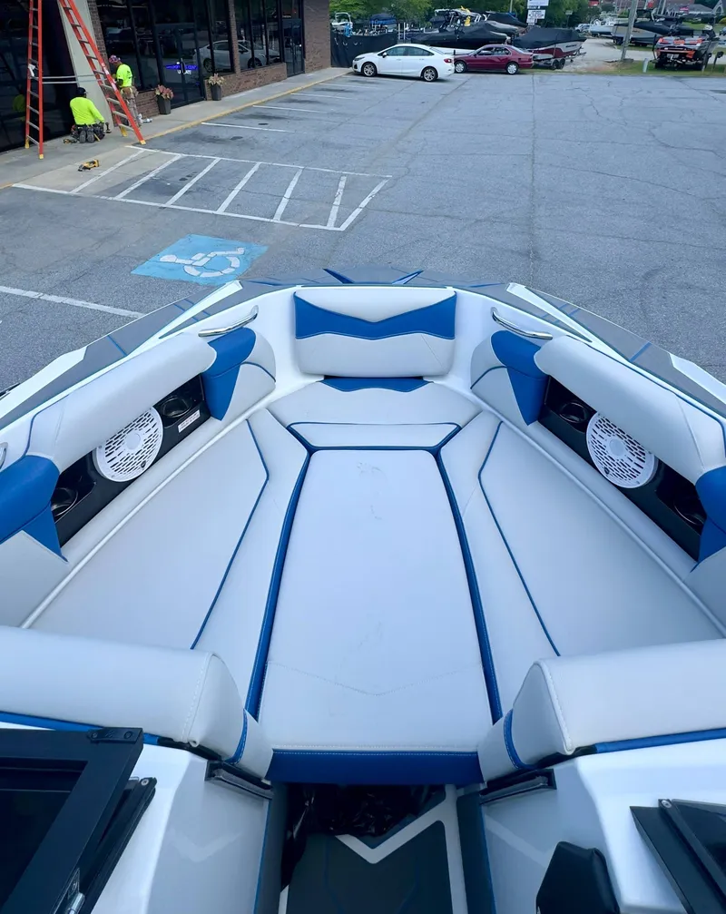 Slide: The Image of The image shows the bow of a 2022 Supreme S220 boat with blue and white upholstery. - 15