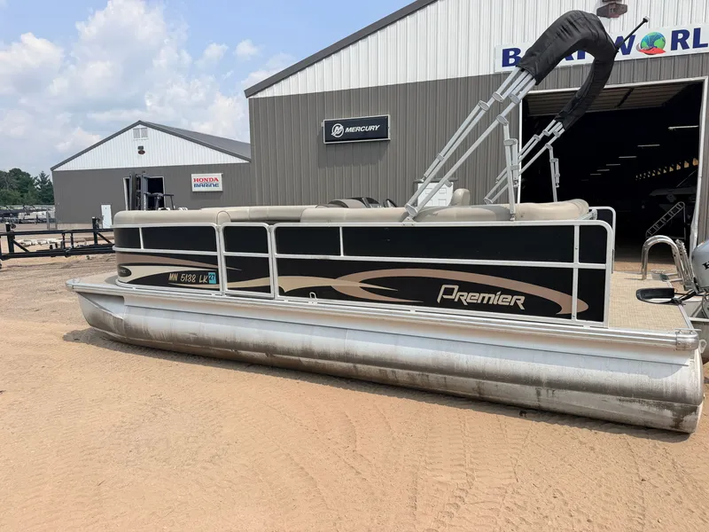 Slide: The Image of A 2016 Premier 220 SunSpree pontoon boat with a 50HP Honda 4-stroke engine, parked on sandy ground. - 45