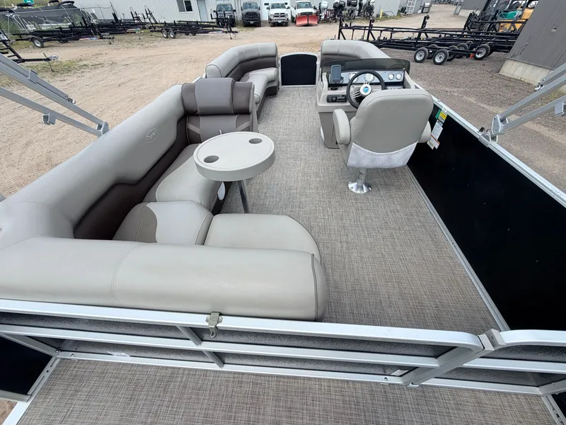 Slide: The Image of The image shows the interior of a Premier 220 SunSpree pontoon boat with beige seating and a table. - 8