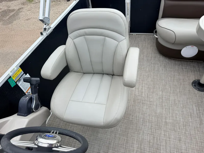 Slide: The Image of A beige captain's chair on a boat with a steering wheel and throttle, surrounded by carpet flooring. - 21