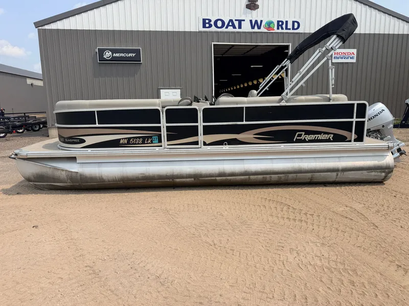 Slide: The Image of A 2016 Premier 220 SunSpree pontoon boat with a 50HP Honda 4-stroke engine, parked outside a boat dealership. - 27