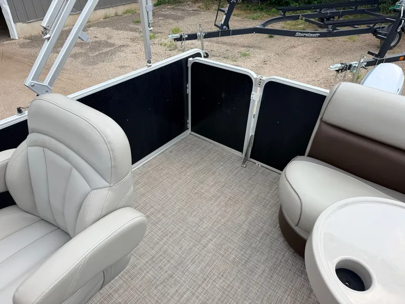 Slide: The Image of The image shows the interior of a Premier 220 SunSpree pontoon boat with beige seats and a table. - 37