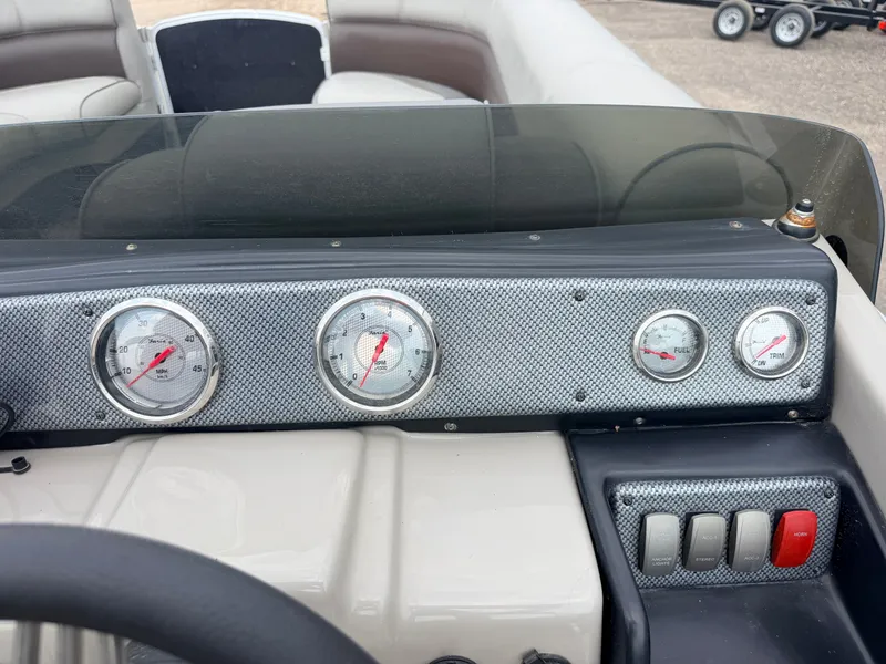 Slide: The Image of The image shows the dashboard of a Premier 220 SunSpree boat with several gauges and switches. - 23