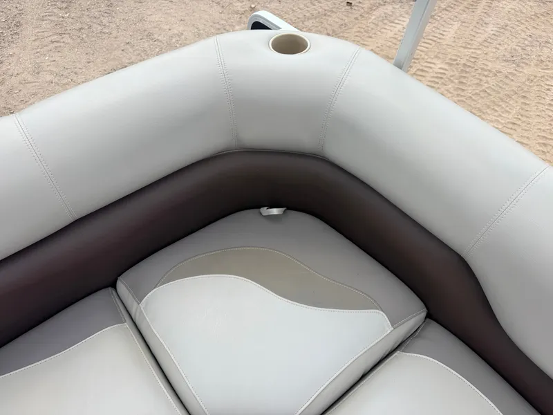 Slide: The Image of Corner of a boat seat with beige and brown upholstery and a cup holder. - 31