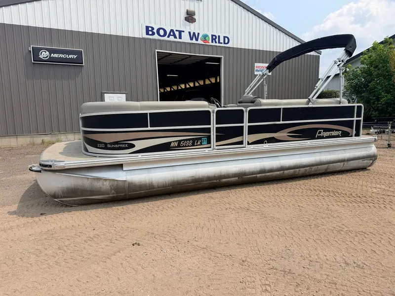 Slide: The Image of A 2016 Premier 220 SunSpree pontoon boat with a 50HP Honda 4-stroke engine, parked outside a building. - 42