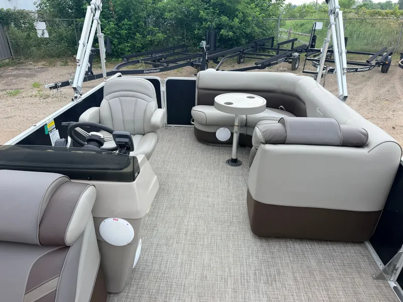 Slide: The Image of The image shows the interior of a 2016 Premier 220 SunSpree pontoon boat with comfortable seating and a small table. - 5