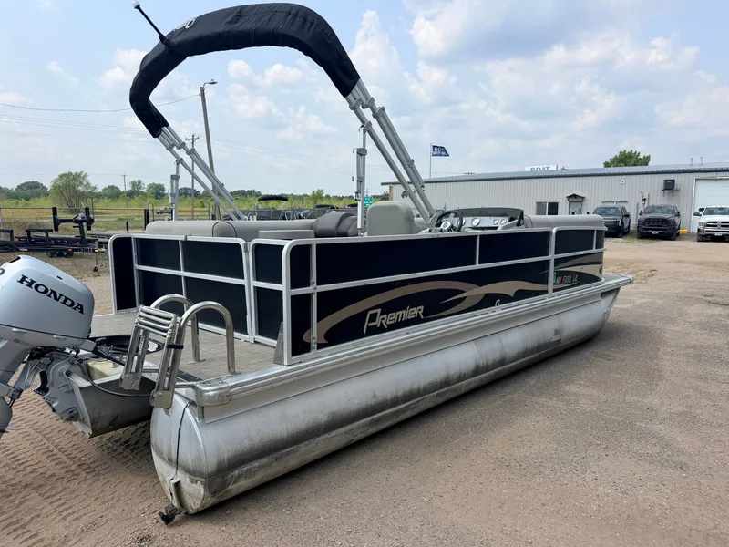 Slide: The Image of A 2016 Premier 220 SunSpree pontoon boat with a 50HP Honda 4-stroke engine, parked on a gravel lot. - 47
