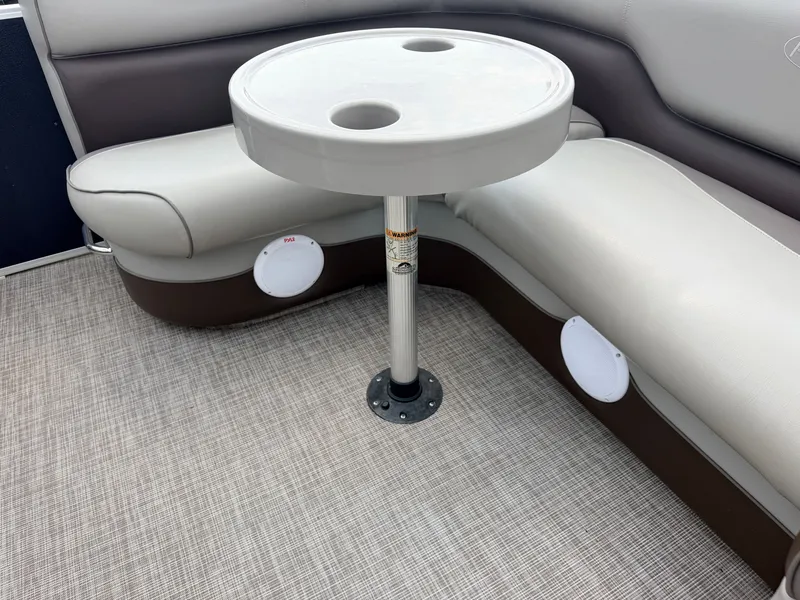 Slide: The Image of Interior of a 2016 Premier 220 SunSpree with a round table and cushioned seating. - 33