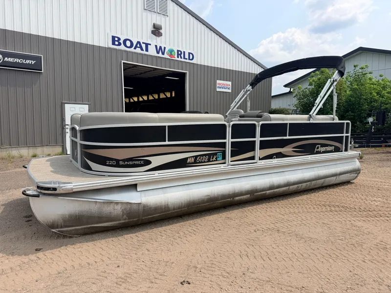 Slide: The Image of A 2016 Premier 220 SunSpree pontoon boat with a 50HP Honda 4-stroke engine, parked outside a building. - 41