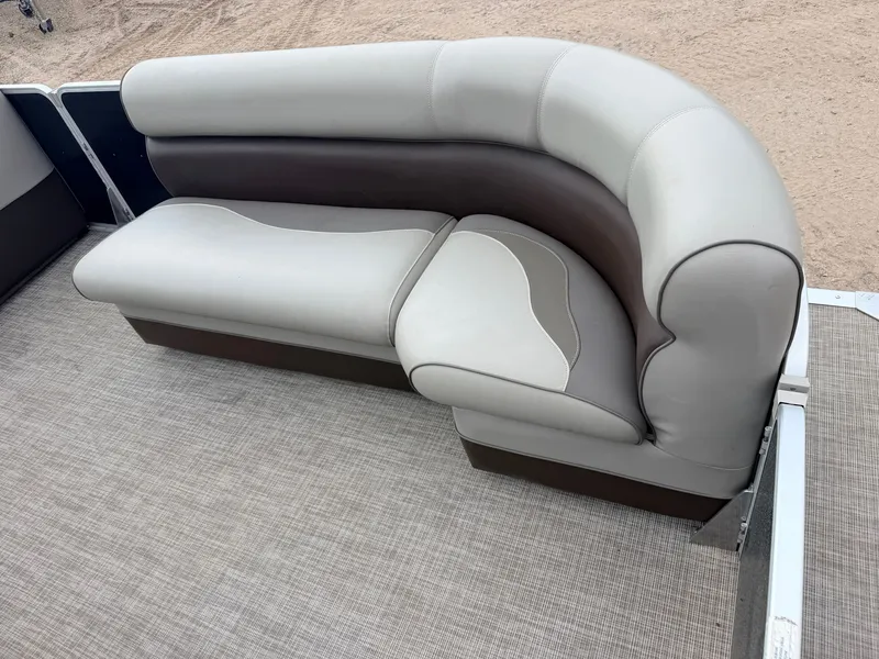 Slide: The Image of A sleek, curved seating sofa on a boat with beige upholstery and brown accents. - 12