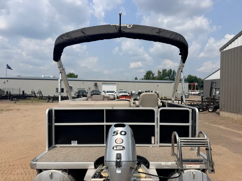 Slide: The Image of A 2016 Premier 220 SunSpree pontoon boat with a 50HP Honda 4-stroke engine, parked in a yard. - 34