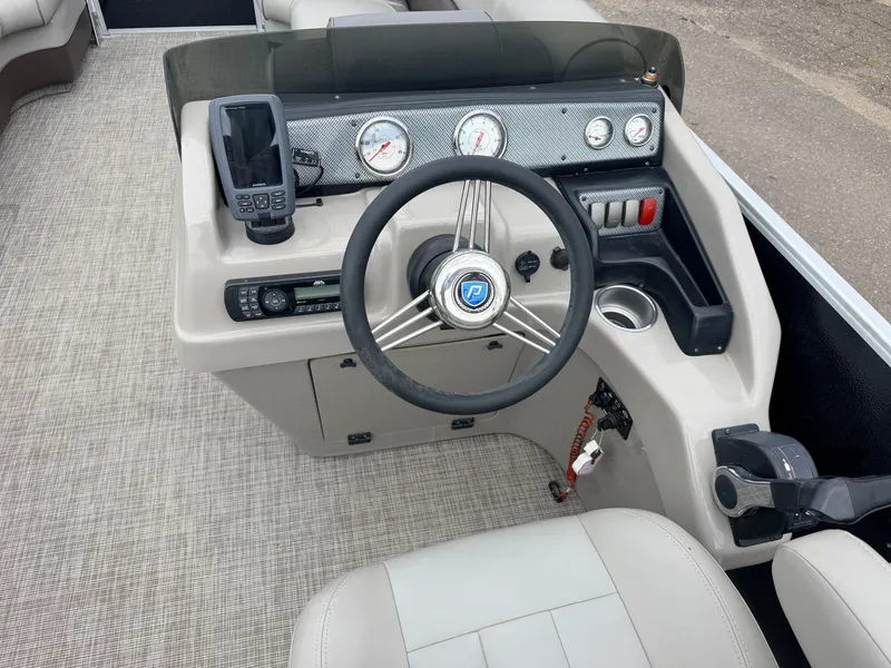 Slide: The Image of The image shows the helm of a Premier 220 SunSpree boat with a sleek steering wheel and gauges. - 22