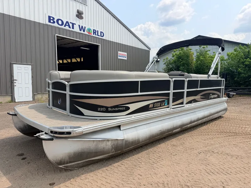 Slide: The Image of A 2016 Premier 220 SunSpree pontoon boat with a 50HP Honda 4-stroke engine, parked on sand. - 40