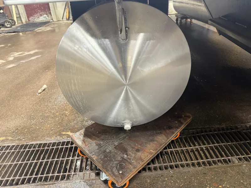 Slide: The Image of Round, shiny metal cylinder on a wheeled platform in a workshop setting. - 35