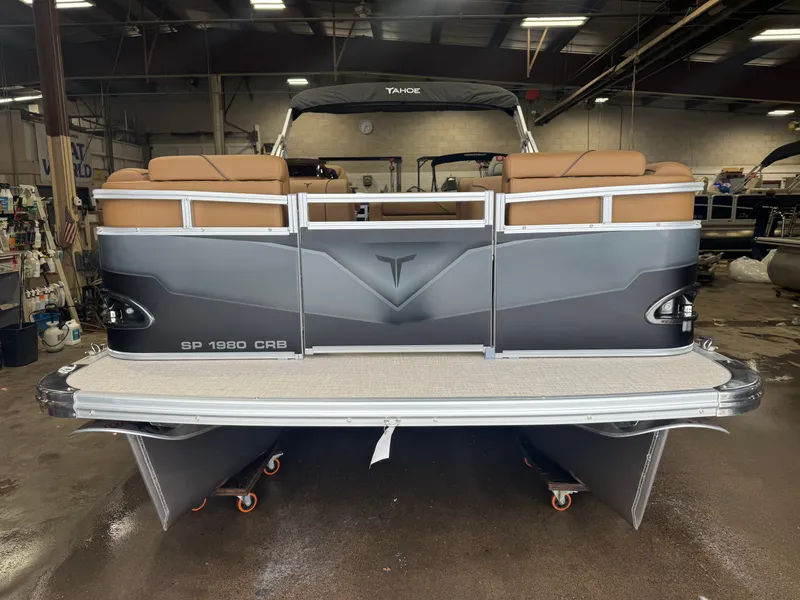 Slide: The Image of A gray pontoon boat with brown seats and a spacious rear area in a workshop. - 31