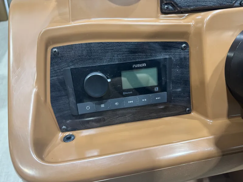 Slide: The Image of Close-up of a boat audio system featuring a Fusion panel and controls. - 12