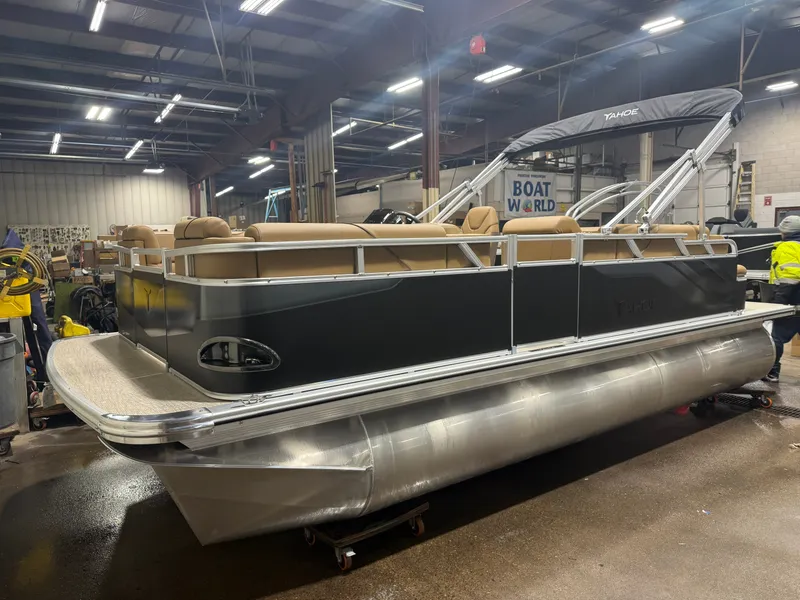 Slide: The Image of A modern pontoon boat with a sleek black hull and beige seating in a warehouse setting. - 33
