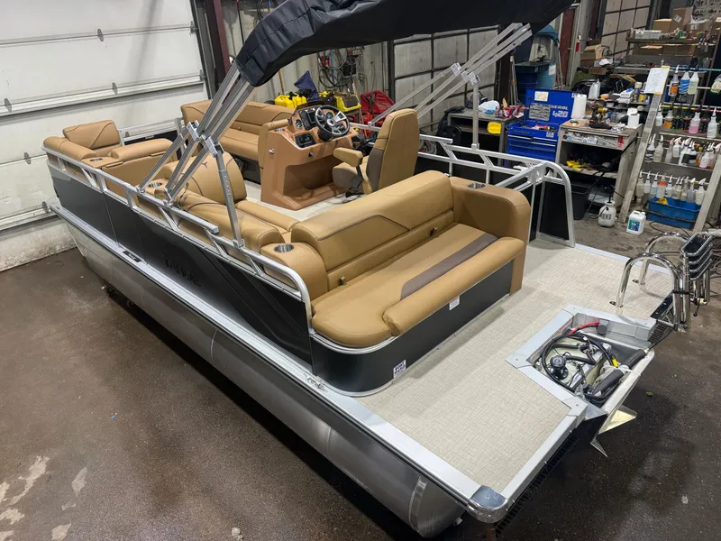 Slide: The Image of A modern pontoon boat with brown seating and a black canopy in a workshop. - 42