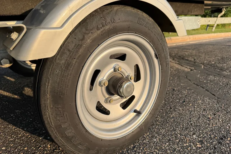 Slide: The Image of Trailer wheel of 2017 Alumacraft MV 1648 Jon boat on asphalt surface. - 18