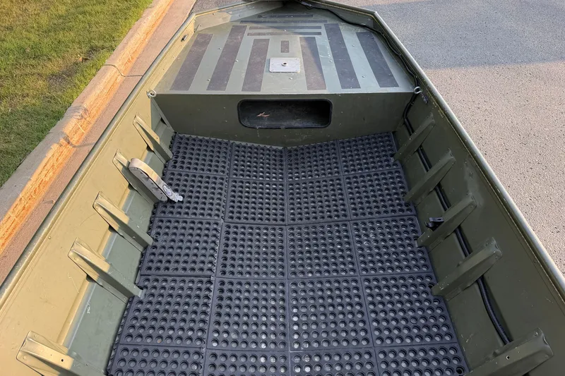 Slide: The Image of 2017 Alumacraft MV 1648 Jon boat interior with non-slip flooring and storage compartment. - 11
