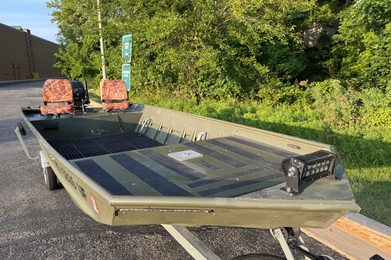 Slide: The Image of 2017 Alumacraft MV 1648 Jon boat on trailer, featuring camouflage seats and LED light bar. - 6