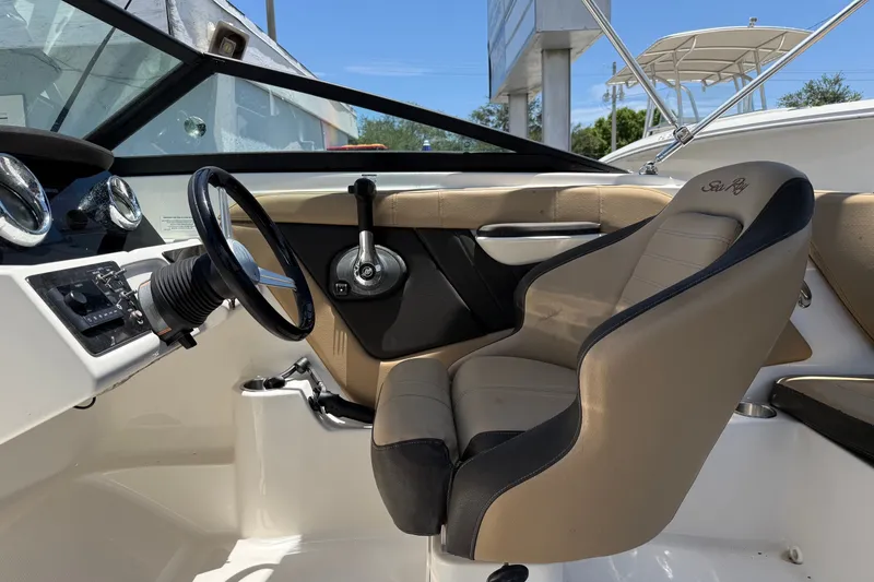 Slide: The Image of 2019 Sea Ray SPX 190 Outboard boat interior with steering wheel and beige seating. - 33