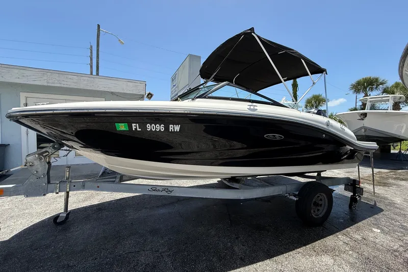 Slide: The Image of 2019 Sea Ray SPX 190 Outboard boat on trailer, black hull, parked outdoors. - 3