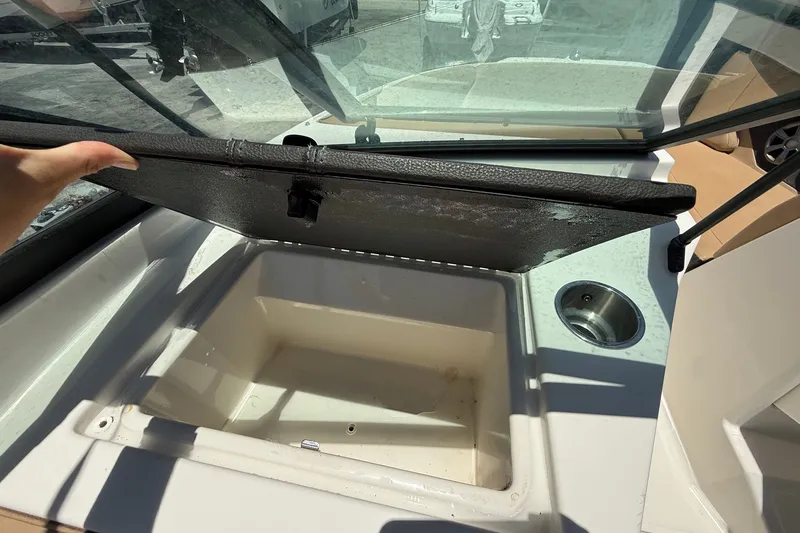 Slide: The Image of 2019 Sea Ray SPX 190 Outboard boat with open storage compartment and cup holder. - 23