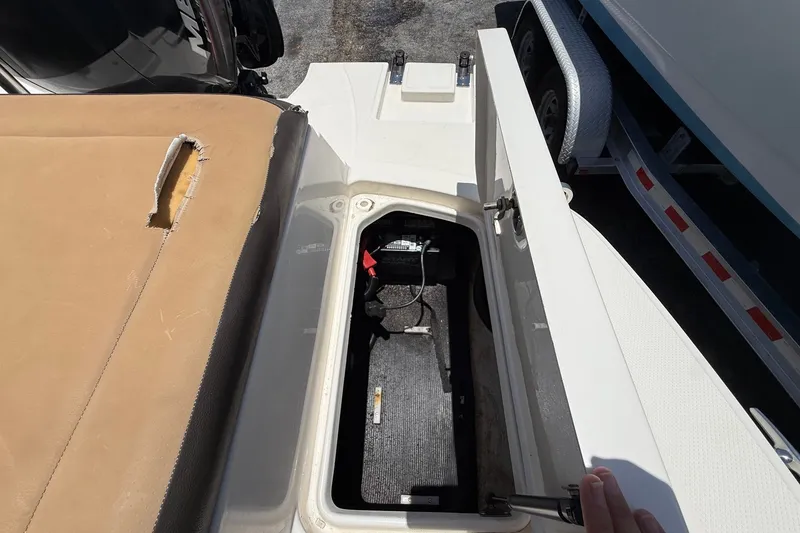 Slide: The Image of 2019 Sea Ray SPX 190 Outboard boat storage compartment with open hatch and visible battery. - 40