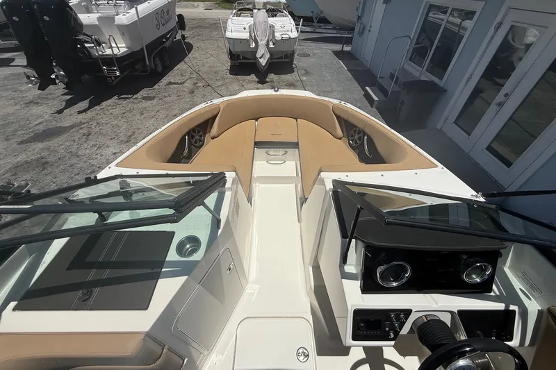Slide: The Image of 2019 Sea Ray SPX 190 Outboard boat interior with tan seating and dashboard view. - 9