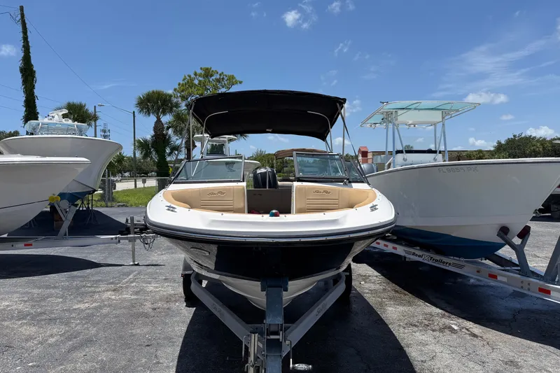 The Image of 2019 Sea Ray SPX 190 Outboard boat on trailer, parked outdoors under clear blue sky. - 0