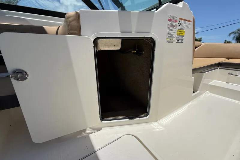 Slide: The Image of 2019 Sea Ray SPX 190 Outboard storage compartment with open door, showcasing interior space. - 20