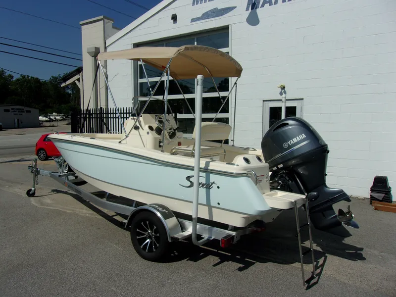 Slide: The Image of A 2026 Scout 188 Sportfish boat on a trailer in front of a building. - 3